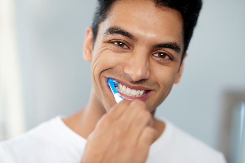Man brushing teeth as part of everyday dental habits at home