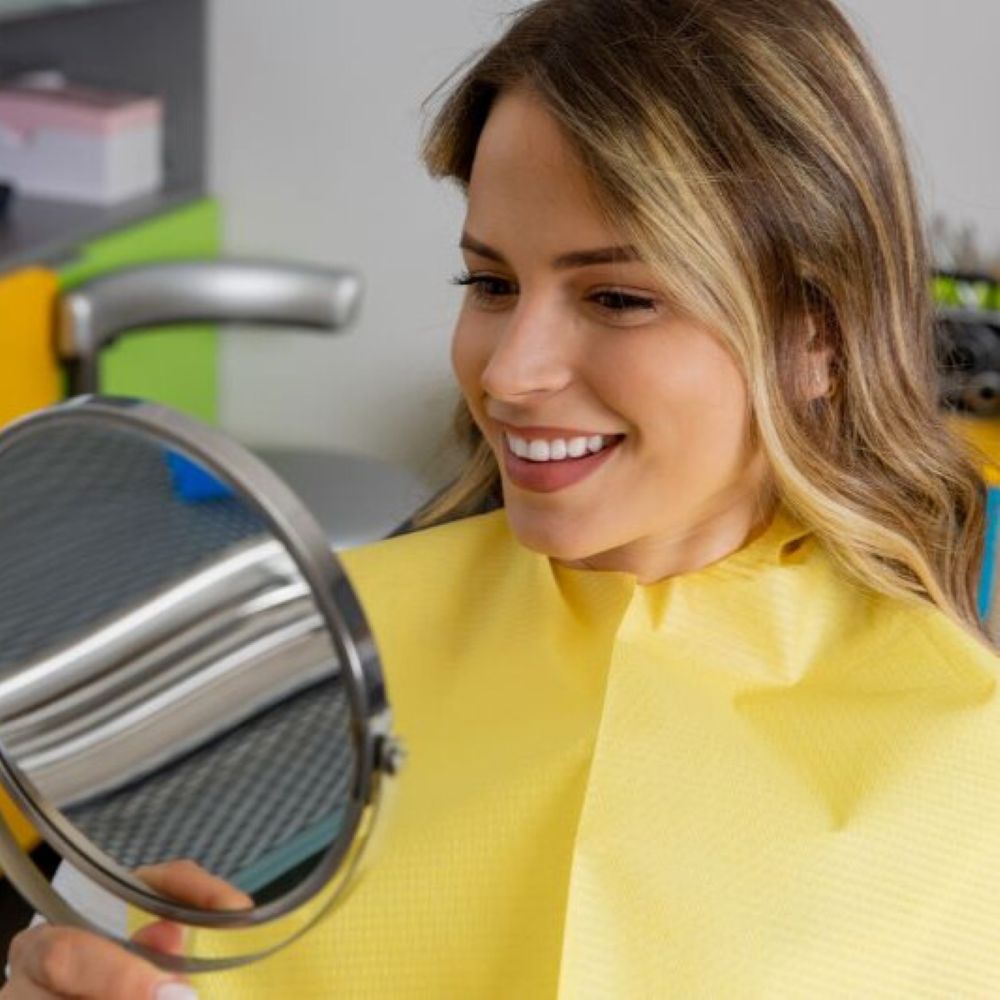 service-dental-exam-wetherill-park Patient smiling while checking teeth after a dental exam in Wetherill Park at Dr Raymond Platon & Associates.