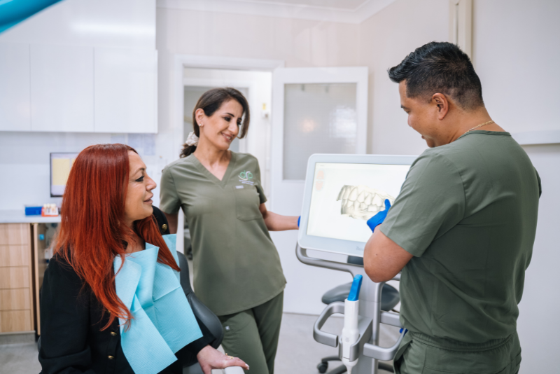 Dr Raymond Platon showing a digital dental scan to a patient using advanced technology at the Wetherill Park clinic.
