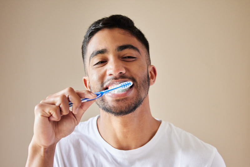 Man brushing his teeth to support oral health while reducing the effects of smoking and vaping at our Wetherill Park dental clinic