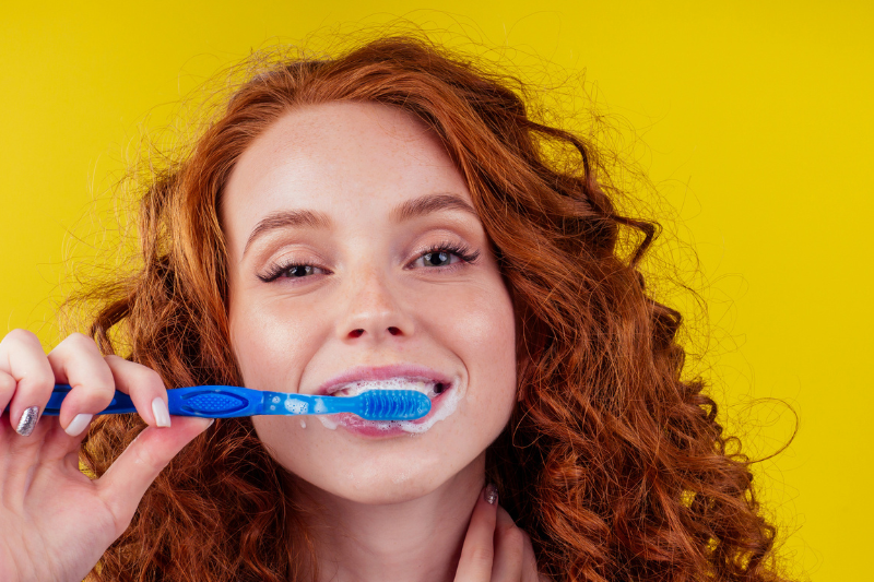 Woman brushing her teeth gently as recommended by our dentist in Wetherill Park to help prevent gum recession