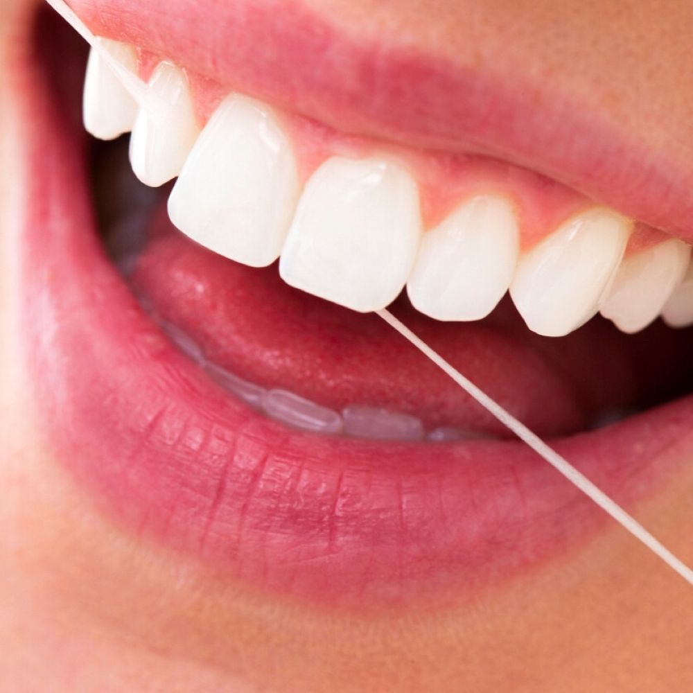 Close-up of a person flossing their teeth to maintain healthy gums and prevent gum disease.