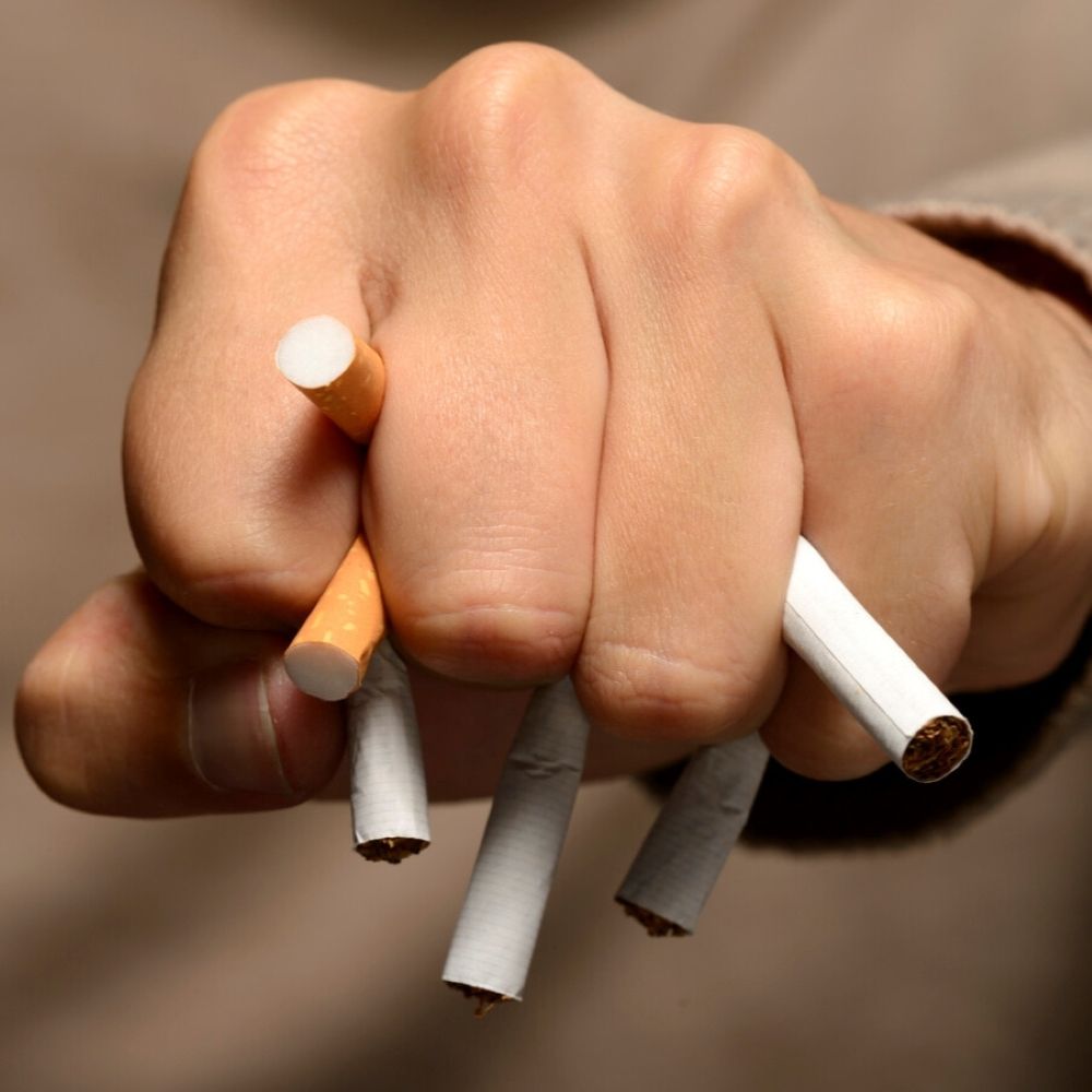 Hand crushing cigarettes to symbolise quitting smoking for better oral health in Wetherill Park.