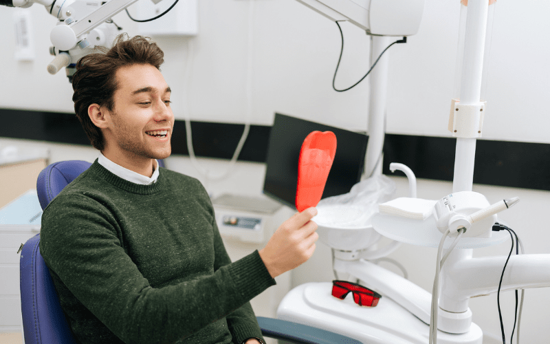 Patient reviewing oral cancer screening findings with a dental mirror in Wetherill Park