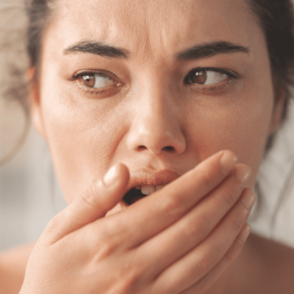 Woman covering mouth due to bad breath seeking treatment in Wetherill Park
