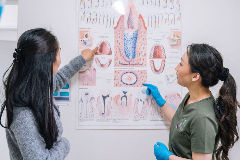 Caroline Nguyen Oral Health Therapist explaining tooth pain causes to patient in Wetherill Park clinic