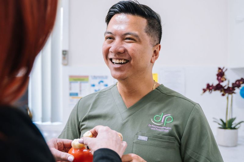Dr Raymond Platon discussing veneer treatment options with patient in Wetherill Park