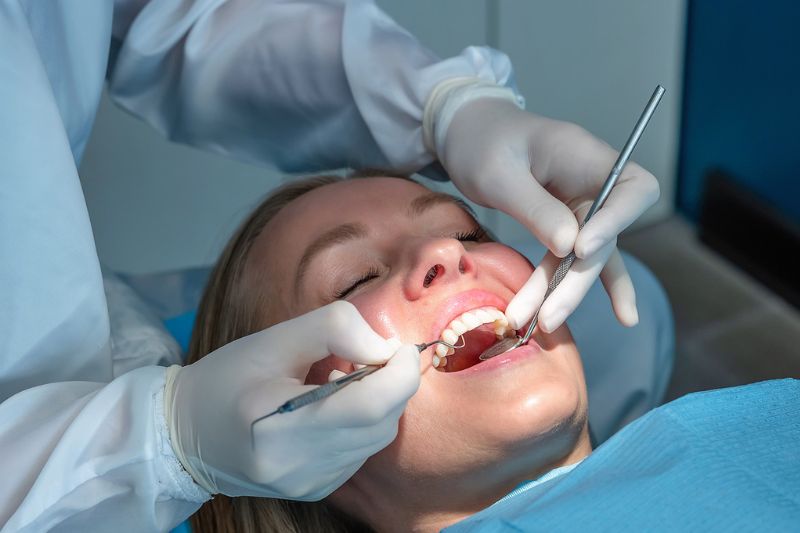Dentist assessing swollen gum around one tooth in Wetherill Park dental clinic