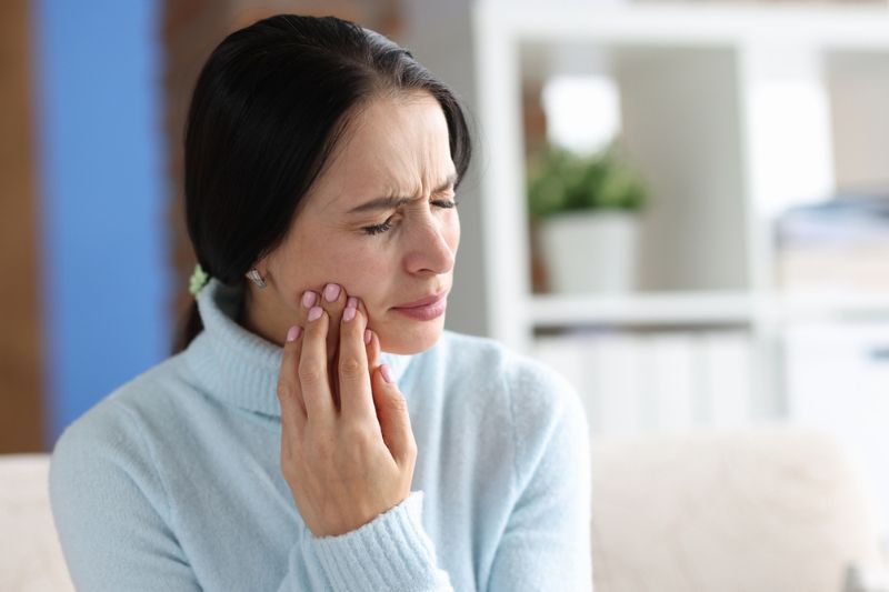 Woman experiencing possible tooth infection symptoms and jaw pain in Wetherill Park