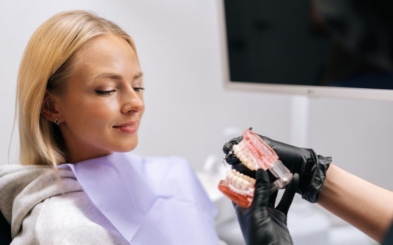 Dentist discussing treatment options with a patient using a dental model
